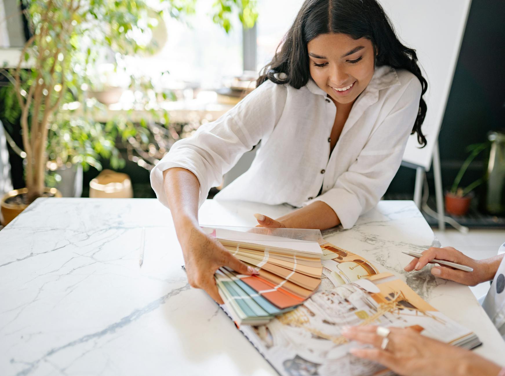 woman holding a palette with color samples and smiling